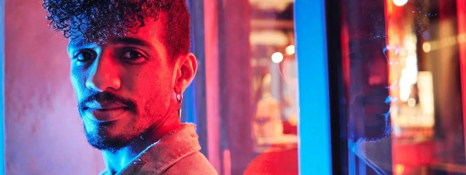 young-hispanic-man-close-to-a-neon-light-with-blue-and-red-lights-e1698314047406-qp9w148nirj6au8ahp533chfvj90fun73j5yjrdisw